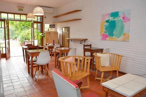 罗萨里奥Hostel Posada Juan Ignacio的餐厅设有木桌、椅子和窗户。