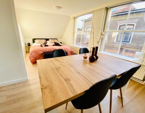 登堡The island life Texel的一间带桌子和床的房间以及一间卧室