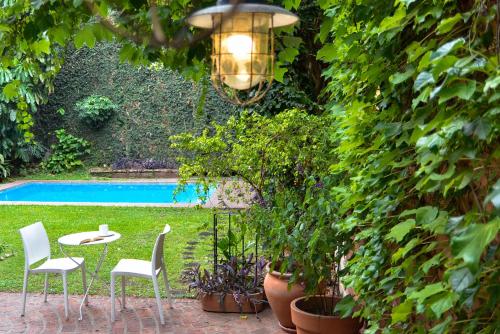 罗萨里奥Hostel Posada Juan Ignacio的一个带桌椅的庭院和一个游泳池