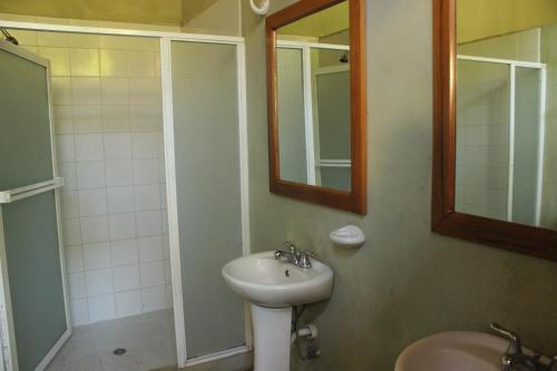格拉纳达Backpackers Inn的一间带水槽、镜子和淋浴的浴室
