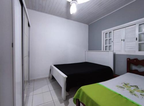 伯迪亚哥Casa individual aconchegante - Rio da praia - Bertioga的一间设有两张床的卧室,位于蓝色墙壁的房间
