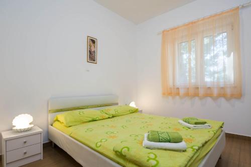 斯坦尼奇Villa Adriatica Excelsior - Beachfront Retreat的一间卧室配有一张带绿色床单的床和一扇窗户。
