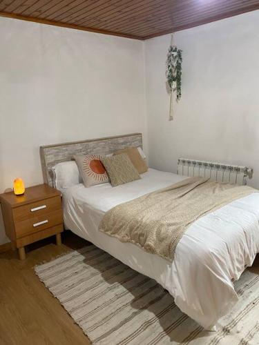 莫斯Casa de campo a 5 min de Vigo的一间卧室配有一张大床和一个床头柜