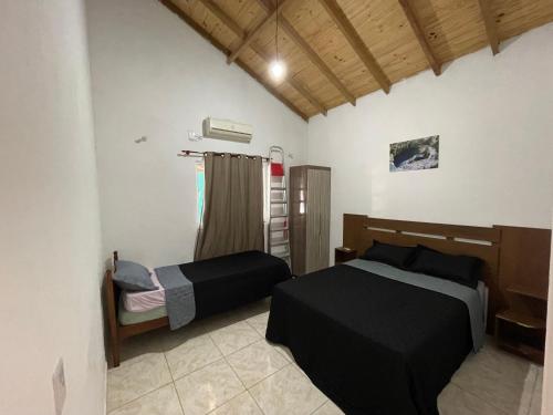 博尼图Casa grande com Piscina e Churrasqueira的一间卧室设有两张床和窗户。