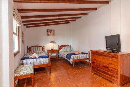 拉克鲁斯Casa Rural Los Orovales的客厅配有两把椅子和电视