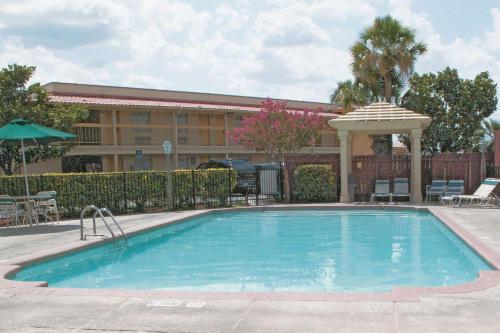 圣安东尼奥Baymont by Wyndham San Antonio South Park的一座游泳池位于酒店前方,设有一座建筑