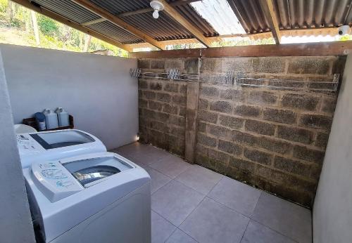 佩尼亚Ipê Eco Village的砖墙房里的洗衣机