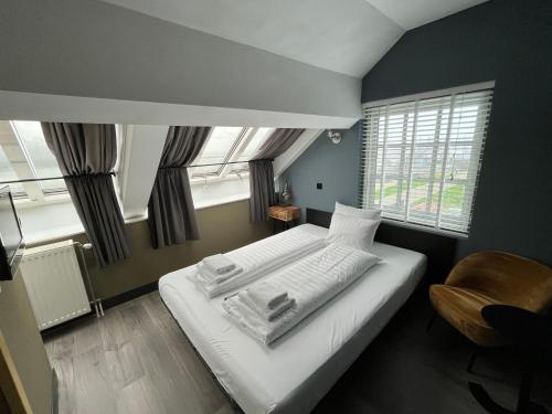 霍恩奥斯特雷兰德酒店的一间卧室配有一张床、一把椅子和窗户。