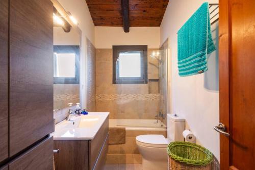 赫罗纳Casa con piscina cerca de Girona的一间带水槽、卫生间和淋浴的浴室