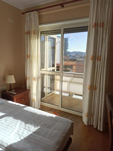 地拉那Home Sweet Rental的一间卧室设有一张床和一个大窗户
