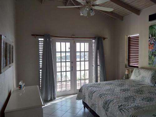 卡斯特里Seascape Villa 3BR with Stunning Caribbean Sea View的一间卧室配有一张床和吊扇