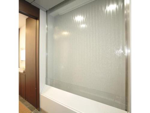 东京R & B Hotel Kamata Higashiguchi - Vacation STAY 38814v的带浴缸的浴室内的玻璃窗