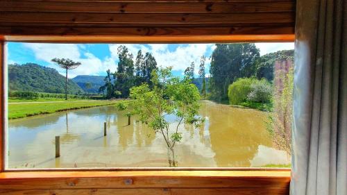 乌鲁比西Pousada Mato Verde - Urubici - SC的享有洪水泛滥河景的窗户