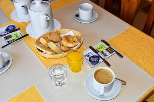 蒂尔卡拉Hotel El Jardin Dante的桌子,上面放着咖啡和一篮面包