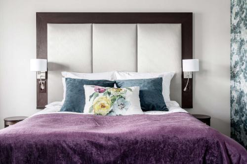 康斯博基登拉弗贝斯特韦斯特优质酒店的一张带紫色棉被和枕头的床