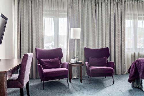 康斯博基登拉弗贝斯特韦斯特优质酒店的酒店客房设有两张紫色椅子和一张桌子