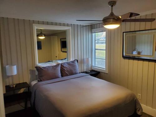 克莱蒙Beautiful cottage near Lake Louisa & mins from Disney, Vehicle Rental Available的一间卧室配有一张大床和吊扇