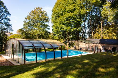索姆河畔的圣瓦列里罗马尔城堡旅馆 - 百德索姆河德的温室和院子内的游泳池