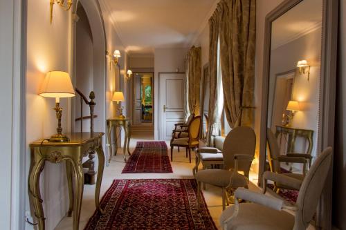 索姆河畔的圣瓦列里罗马尔城堡旅馆 - 百德索姆河德的走廊上设有椅子、桌子和镜子