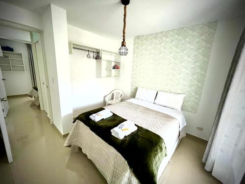 奥克萨潘帕Colina Haus, hospedaje Oxapampa的一间卧室配有一张床,上面有两条毛巾