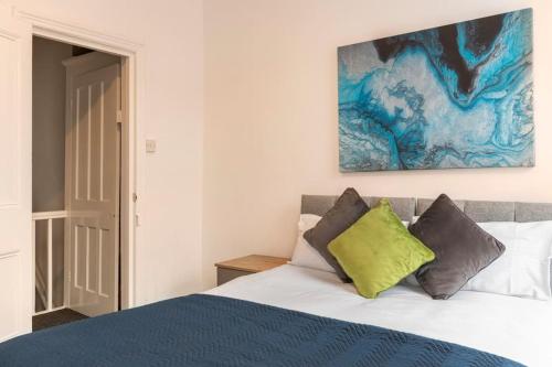 利物浦3-bedroom Home in Liverpool L15 with FREE Parking的卧室配有一张床,墙上挂有绘画作品