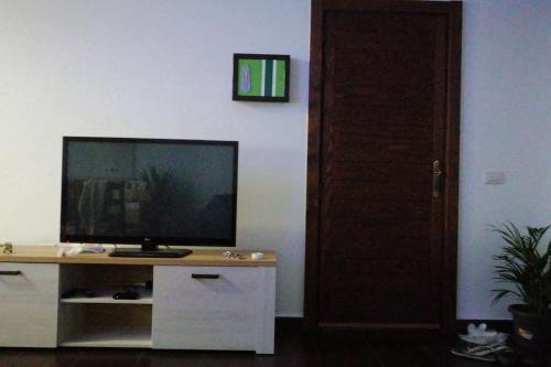 卡门港Portonovo Great Ocean的一间客厅,配有一张桌子上放的电视