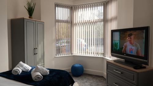 NelsonReedley House的卧室设有平面电视和窗户。