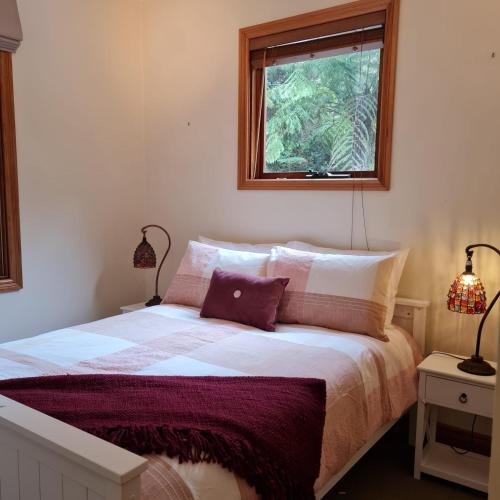 沃尔哈拉Whitlow Manor的一间卧室配有一张带两盏灯的床和一扇窗户。