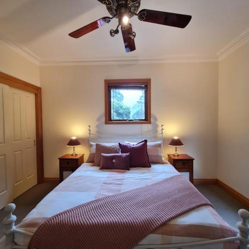 沃尔哈拉Whitlow Manor的一间卧室配有一张带吊扇的床