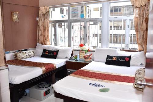 香港London Guest House的客房设有两张床和窗户。