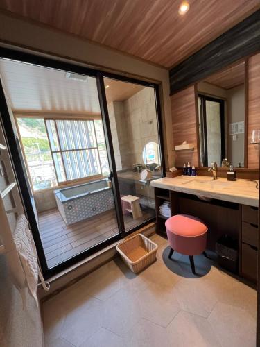 日光丸京日式旅馆的一间带水槽和大窗户的浴室