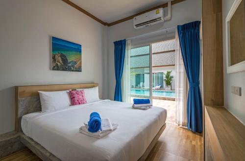 奥南海滩Amadha Villas Retreat - Free Tuk-Tuk Service To the Beach的一间卧室设有一张床和一个大窗户