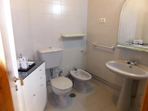 波尔图海滩公寓的白色的浴室设有卫生间和水槽。