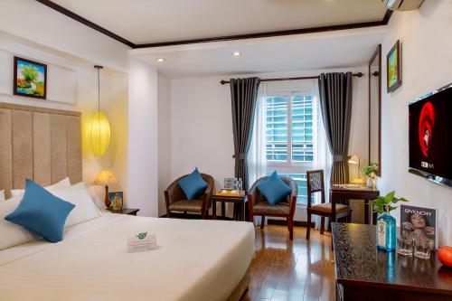 河内Babylon Grand Hotel & Spa的配有一张床和一张书桌的酒店客房