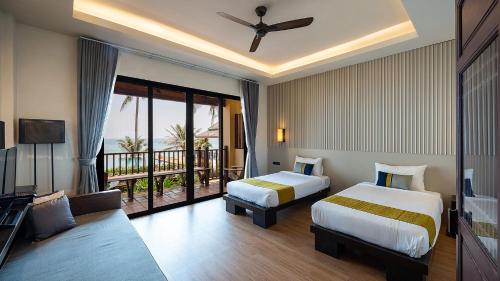 邦沙潘河內班赛通海滩度假酒店的酒店客房设有两张床和一个阳台。