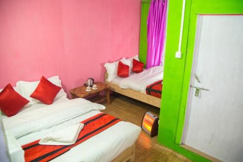 NātangHill Home Stay, Baichung的配有粉红色和绿色墙壁的客房内的两张床