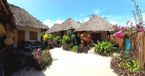 马特姆维Morningstar Bungalows Zanzibar的茅草屋顶的一排小屋
