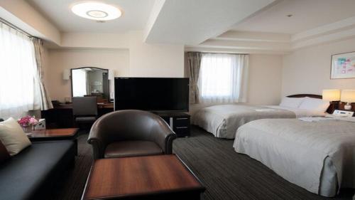 盛冈HOTEL BRIGHT INN MORIOKA的酒店客房,设有两张床和一张沙发