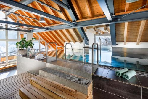 维尔德豪斯Hotel Hirschen Wildhaus的浴室配有木制天花板和带长凳的盥洗池