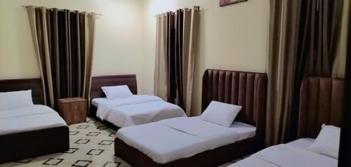 拜尔卡AlZaeem Resort & Hotels的酒店客房,设有两张床和窗帘