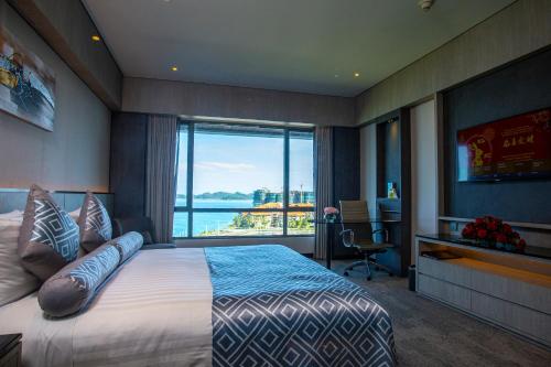 哥打京那巴鲁太平洋丝绸酒店的一间卧室设有一张大床和一个大窗户