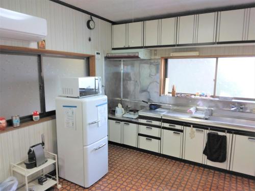 ゲストハウスみちしお的厨房配有白色冰箱和水槽
