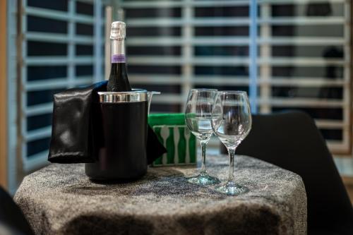 卡塔尼亚Terra Mia Suite的桌子上放有一瓶葡萄酒和两杯酒
