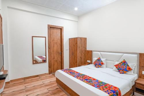阿格拉FabHotel Sirtaj Suites的一间卧室配有一张大床和镜子