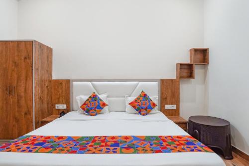 阿格拉FabHotel Sirtaj Suites的一间卧室配有一张带五颜六色棉被的床