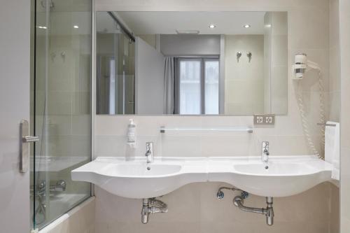 圣塞瓦斯蒂安格罗斯迎宾酒店的一间带两个盥洗盆和大镜子的浴室