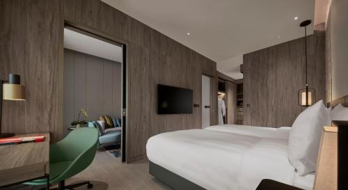 吉隆坡Pan Pacific Serviced Suites Kuala Lumpur的配有一张大床和镜子的酒店客房