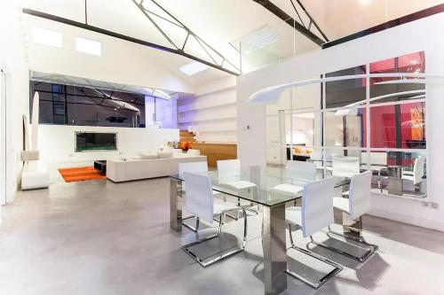 马德里Apartamento inigualable en Retiro的一间设有玻璃桌和白色椅子的用餐室