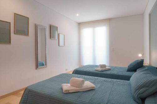 维拉摩拉Aquamar 416 by Vilamoura Sun espaçoso的卧室内的两张床和毛巾