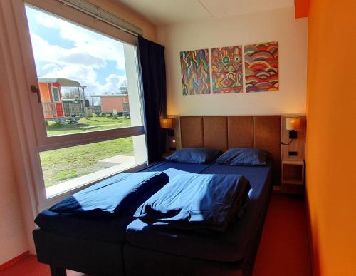 阿姆斯特丹Camping Zeeburg Amsterdam的一间卧室设有一张床和一个大窗户